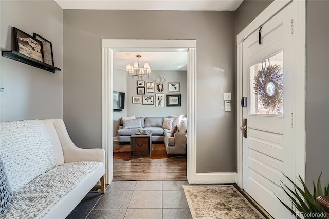 entrance foyer featuring baseboards, a chandelier, and tile patterned floors