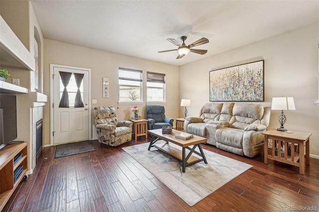 living room with ceiling fan and dark wood-type flooring