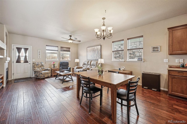 dining space featuring ceiling fan with notable chandelier and dark hardwood / wood-style floors