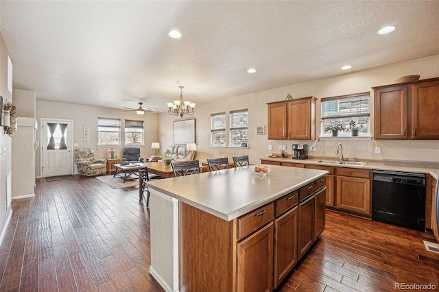 kitchen with dishwasher, sink, hanging light fixtures, a kitchen island, and ceiling fan with notable chandelier