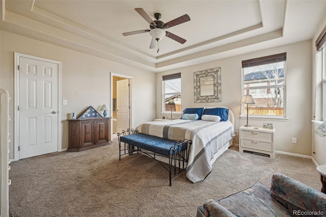 bedroom featuring carpet floors, a tray ceiling, and ceiling fan