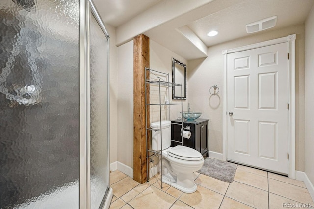 bathroom with tile patterned flooring, vanity, a shower with shower door, and toilet