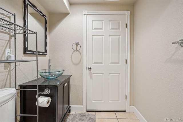 bathroom featuring tile patterned flooring, vanity, and toilet