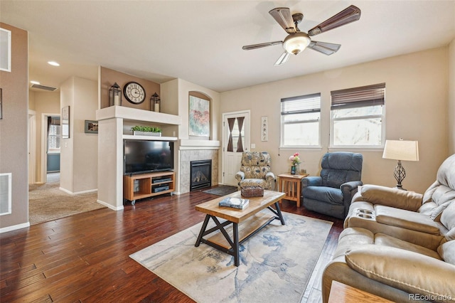 living room with a fireplace, dark hardwood / wood-style flooring, and ceiling fan