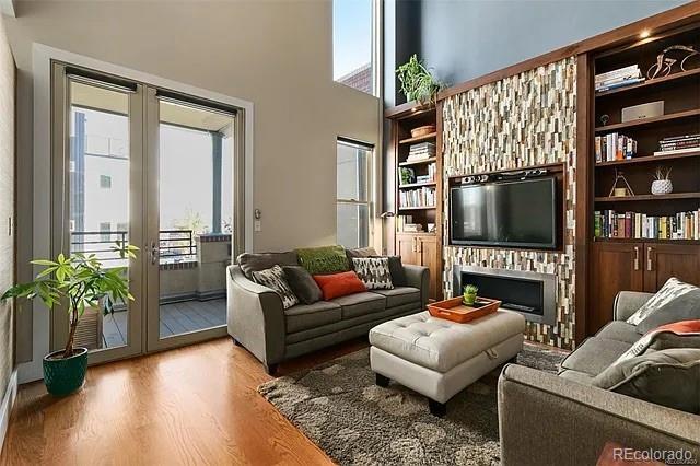 living room with hardwood / wood-style flooring, french doors, and a high ceiling