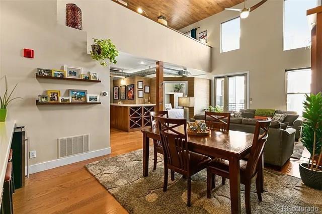 dining room with a towering ceiling and light wood-type flooring