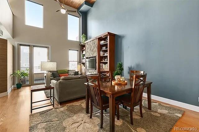 dining area featuring hardwood / wood-style flooring and a towering ceiling