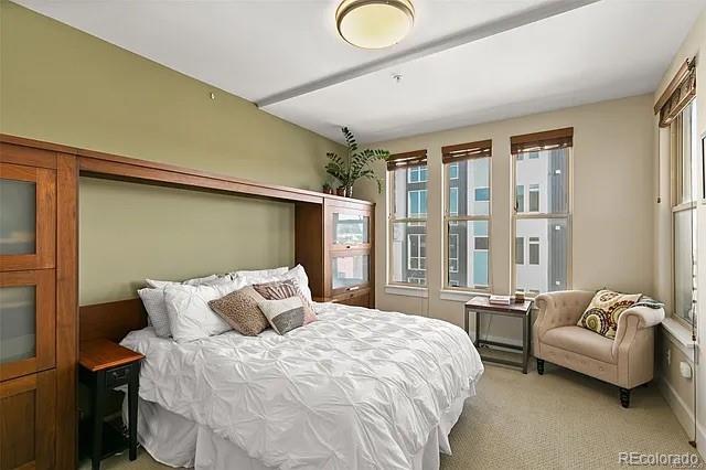 bedroom featuring light colored carpet and multiple windows