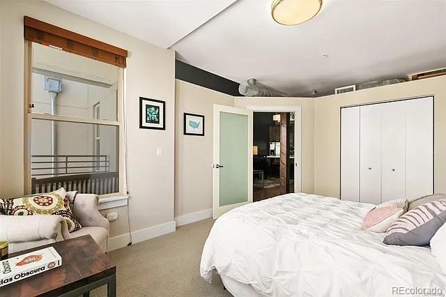 bedroom featuring light colored carpet and a closet