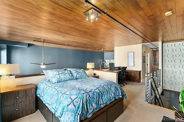 bedroom featuring wood ceiling, light colored carpet, and track lighting