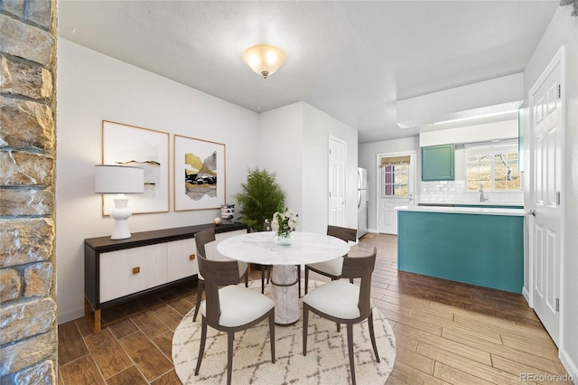 dining area featuring wood tiled floor and baseboards