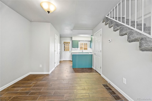 kitchen with dark wood-type flooring, visible vents, baseboards, and tasteful backsplash