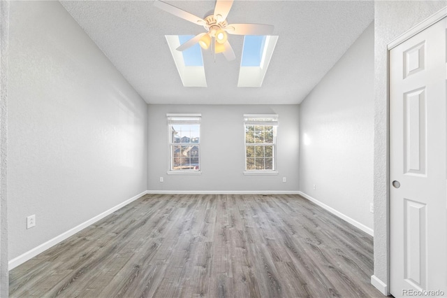 unfurnished room featuring a textured ceiling, wood finished floors, a ceiling fan, and baseboards