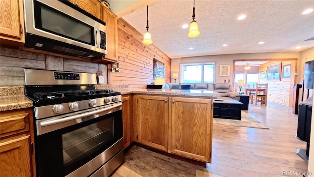 366 Gcr 4421, Grand Lake, CO 80557 - kitchen with appliances with stainless steel finishes, a peninsula, a textured ceiling, wood finished floors, and wooden walls