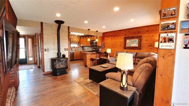 366 Gcr 4421, Grand Lake, CO 80557 - living room with a wood stove, recessed lighting, wooden walls, light wood-type flooring, and a textured ceiling