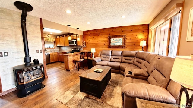 366 Gcr 4421, Grand Lake, CO 80557 - living room with a wood stove, a textured ceiling, light wood finished floors, recessed lighting, and wooden walls