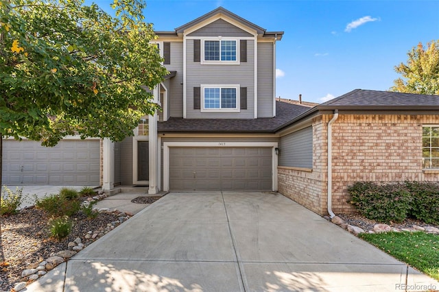 view of front of property featuring a garage, concrete driveway, and brick siding