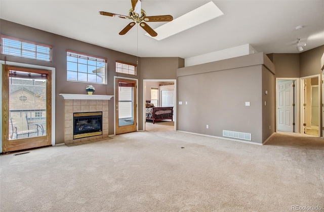 unfurnished living room with ceiling fan, carpet, and a fireplace