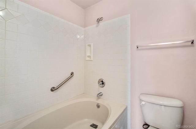 bathroom featuring toilet and tiled shower / bath