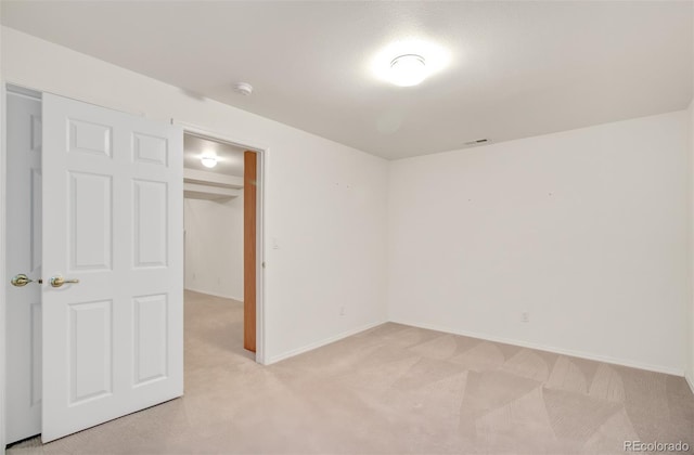 unfurnished bedroom featuring a closet and light colored carpet