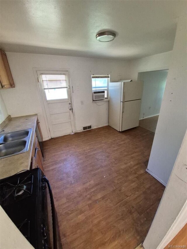 1266 Del Mar Pkwy, Aurora, CO 80010 - kitchen featuring freestanding refrigerator, a sink, range with gas stovetop, wood finished floors, and cooling unit