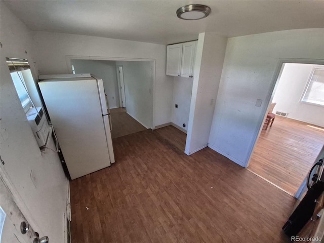 1266 Del Mar Pkwy, Aurora, CO 80010 - kitchen with freestanding refrigerator, wood finished floors, white cabinetry, and baseboards
