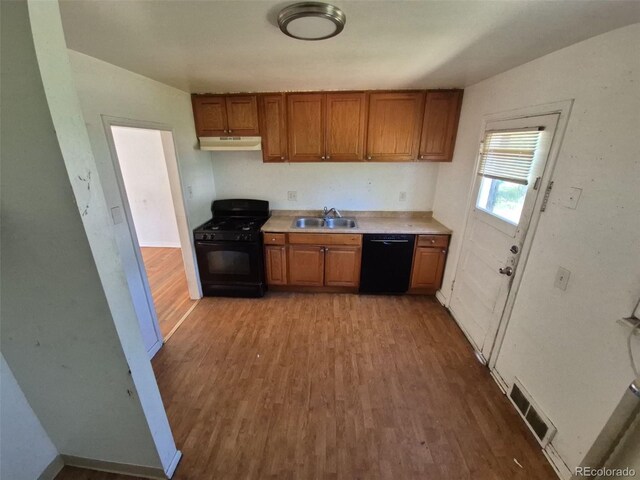 1266 Del Mar Pkwy, Aurora, CO 80010 - kitchen with black appliances, under cabinet range hood, a sink, and brown cabinets