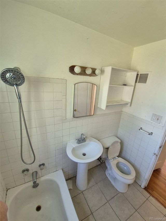 1266 Del Mar Pkwy, Aurora, CO 80010 - bathroom with tile walls, tile patterned flooring, toilet, and a wainscoted wall