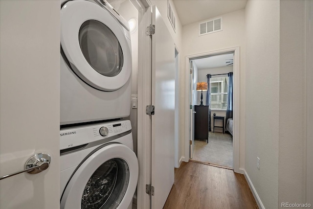 1841 S Dunkirk St Unit 207, Aurora, CO 80017 - laundry room featuring stacked washer / dryer and wood finished floors
