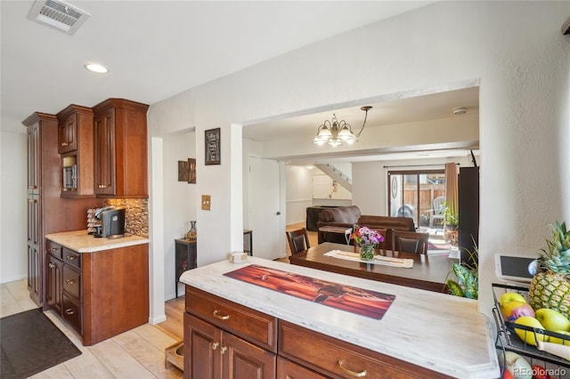 kitchen with open floor plan, backsplash, a chandelier, recessed lighting, and pendant lighting