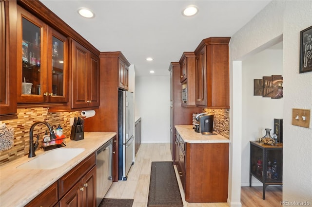 kitchen featuring appliances with stainless steel finishes, a sink, backsplash, light countertops, and recessed lighting