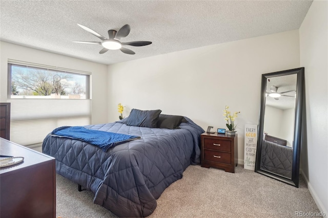 bedroom with a textured ceiling, carpet, and ceiling fan