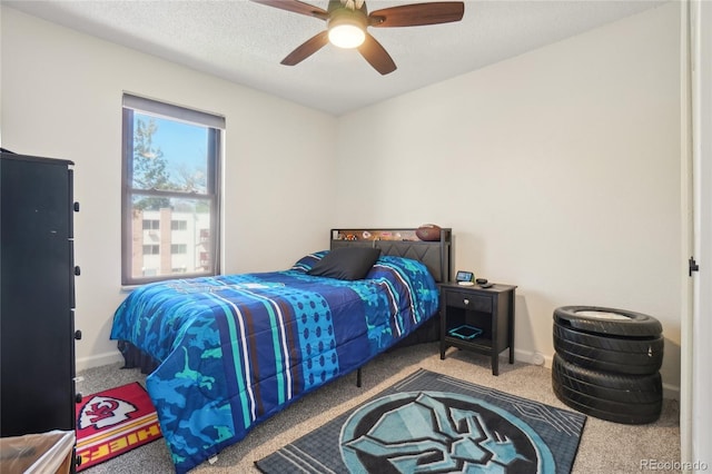 carpeted bedroom with ceiling fan and baseboards
