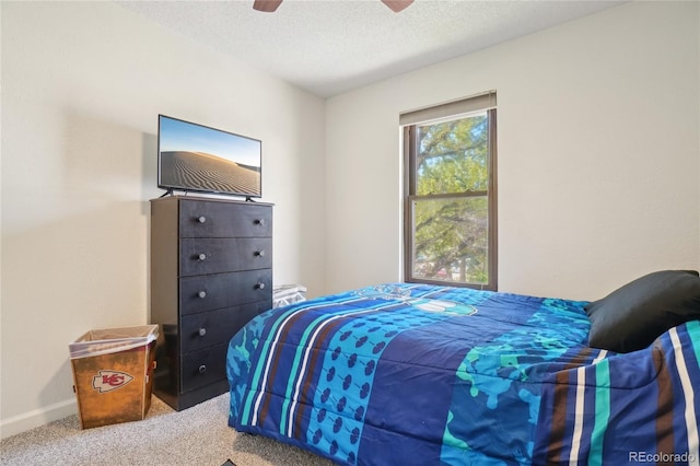 carpeted bedroom with baseboards, a ceiling fan, and a textured ceiling