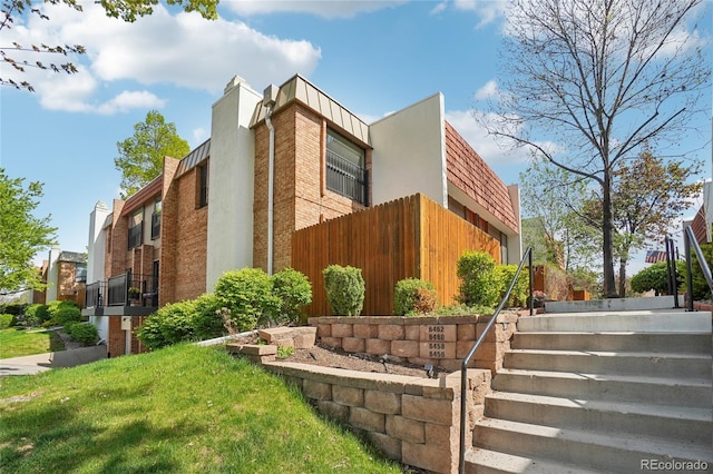 view of home's exterior featuring fence and stairway