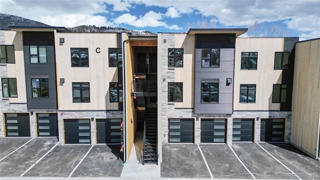 view of building exterior featuring an attached garage and stairs