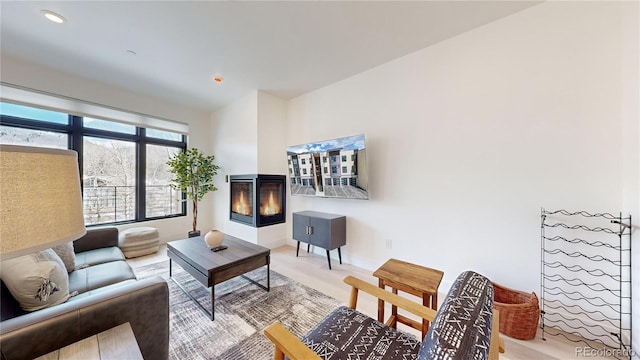 living area featuring recessed lighting and a multi sided fireplace