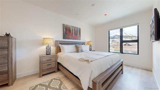 bedroom with light wood-style flooring and baseboards