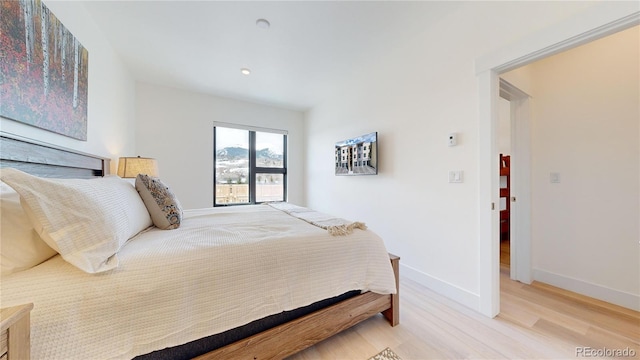 bedroom with baseboards and wood finished floors