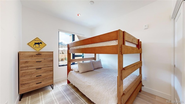 bedroom with baseboards and wood finished floors