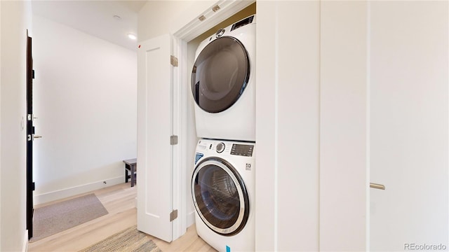 washroom with laundry area, stacked washer / dryer, and light wood-style flooring