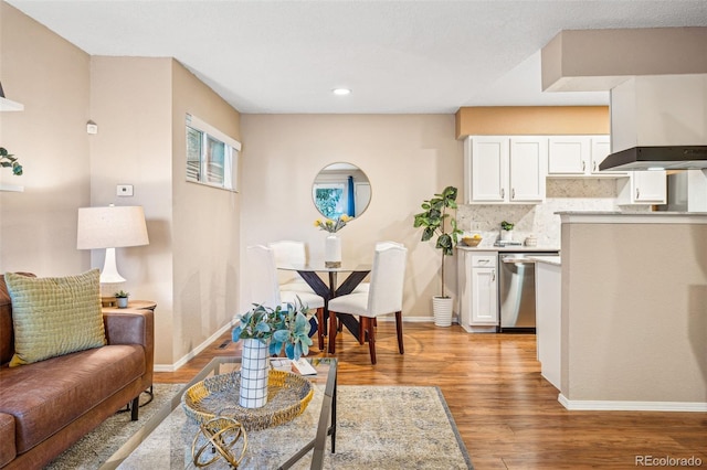 living area with light wood-type flooring, baseboards, and recessed lighting