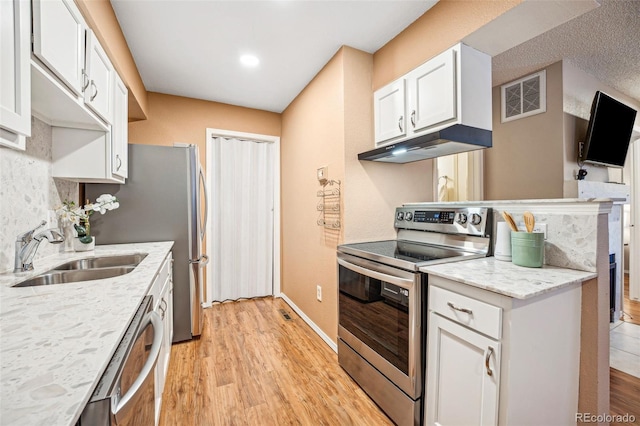 kitchen with visible vents, stainless steel appliances, under cabinet range hood, white cabinetry, and a sink