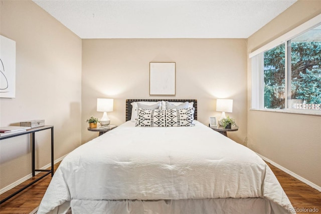 bedroom with wood finished floors and baseboards