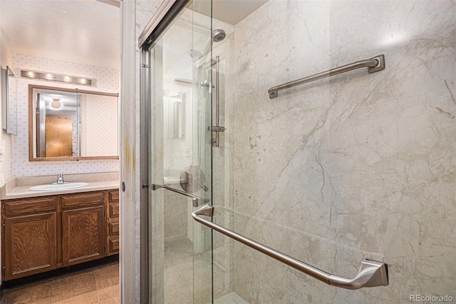 bathroom with a shower with door and vanity