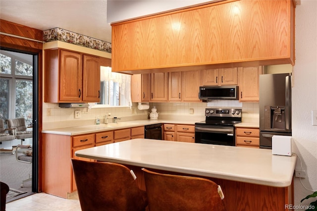 kitchen with appliances with stainless steel finishes, decorative backsplash, a kitchen breakfast bar, and kitchen peninsula