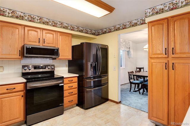 kitchen featuring appliances with stainless steel finishes and decorative backsplash