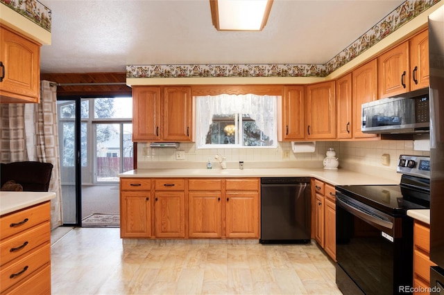 kitchen with backsplash, sink, and black appliances