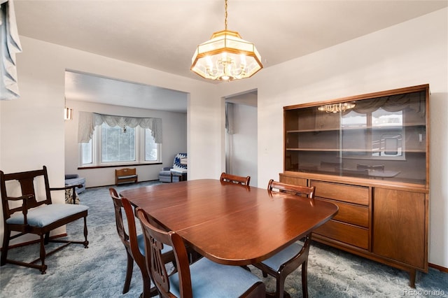 dining area with an inviting chandelier and carpet flooring