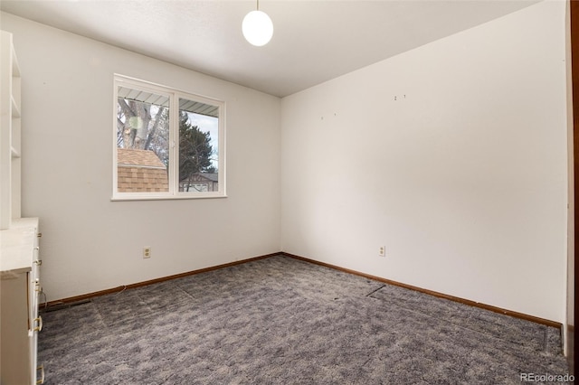 spare room with dark carpet